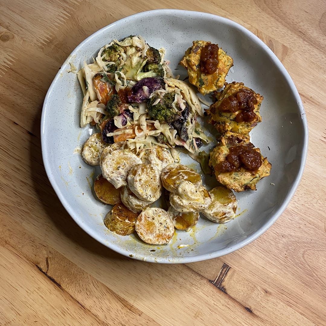 dinner bowl with tempeh bites and tomato chutney, roasted paprika and oregano potates in yoghurt dressing, and roasted heirloom carrot and broccoli slaw