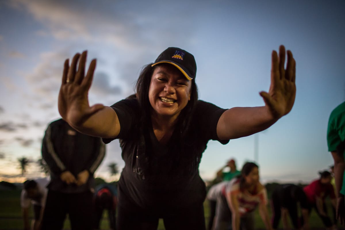 early morning movement - woman high fiving the camera at dawn